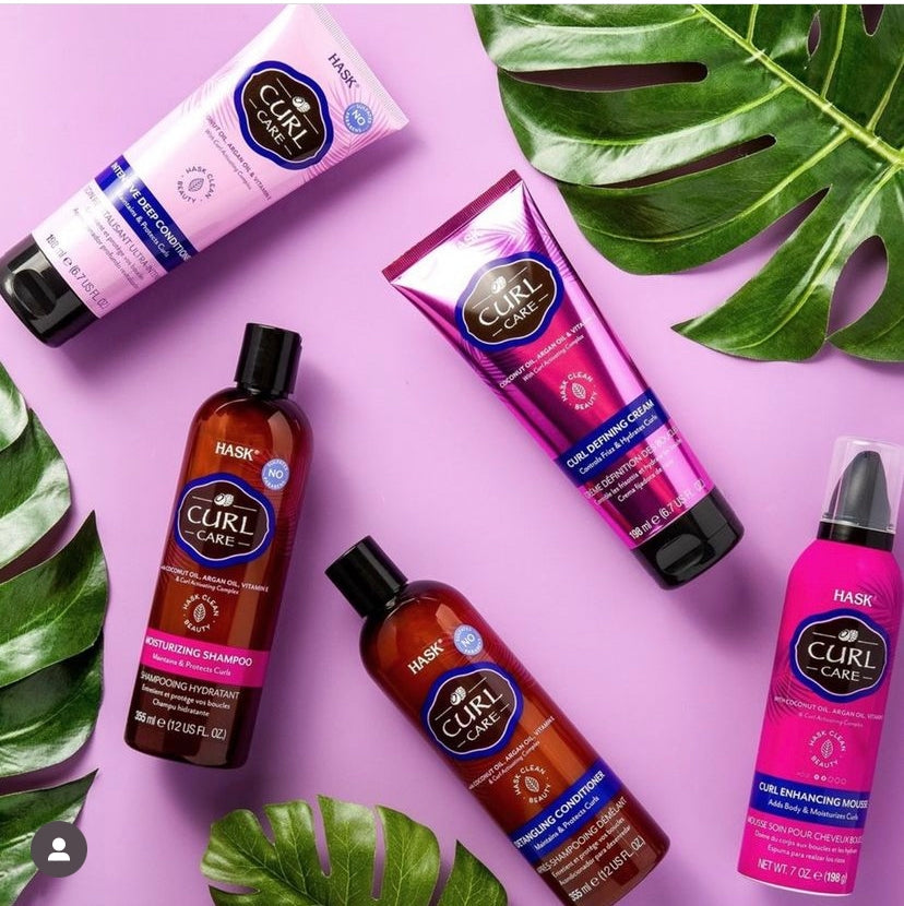 Hask Curl Care hair products displayed on a purple background with green leaves.