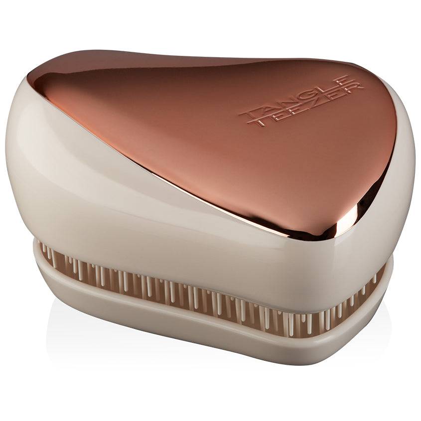 Tangle Teezer Compact Styler in Rose Gold-Ivory, a portable hairbrush with a protective cover. Designed for effortless detangling and smoothing on the go.