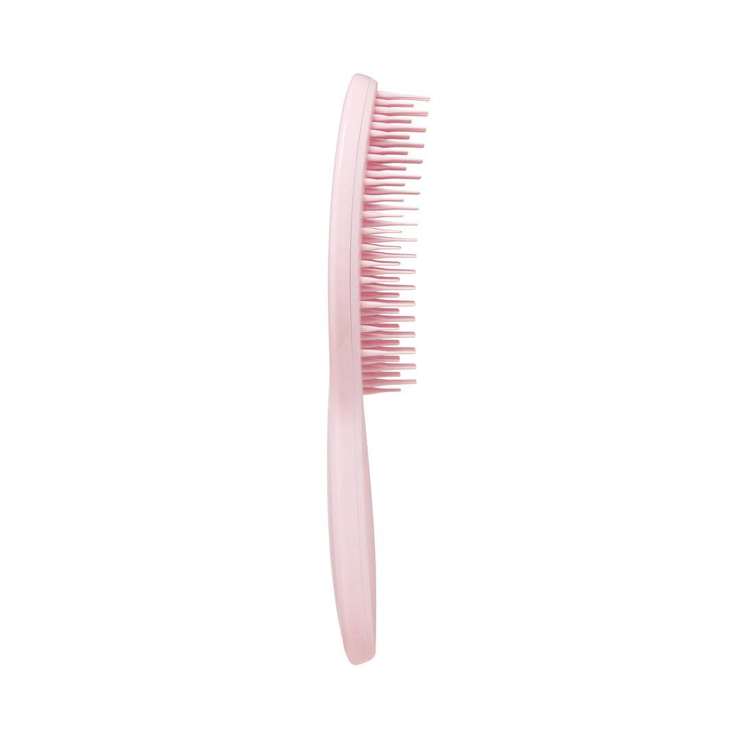 Side view of Tangle Teezer The Ultimate Styler Millennial Pink Hair Brush showcasing its curved design and flexible bristles for effortless hair styling.