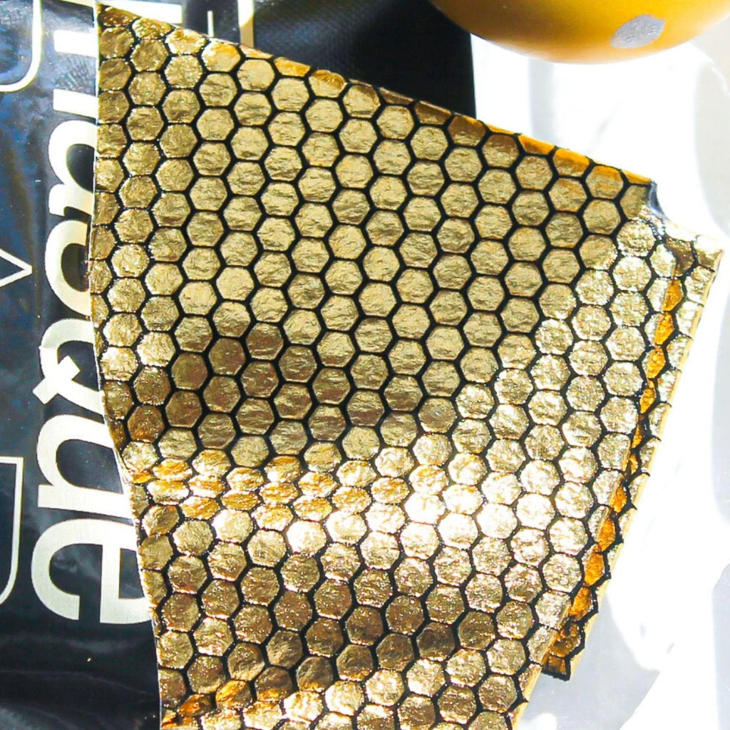 Close-up of Masque Bar Black Gold Foil Mask's hexagonal gold foil texture, designed for deep cleansing and radiance boosting.
