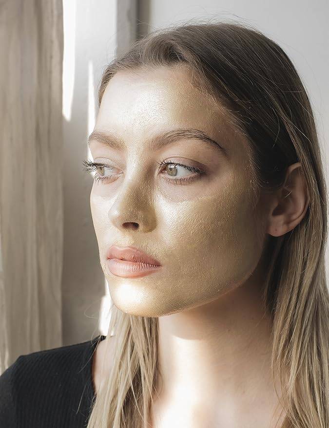 Woman wearing Masque Bar Gold Foil Peel-Off Mask, showcasing radiant skin treatment for detoxifying and brightening dull complexions.