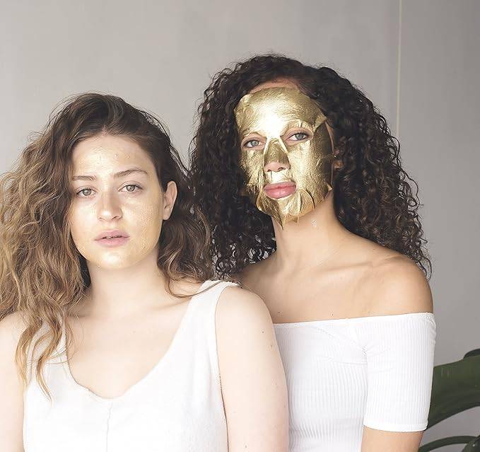 Two women using Masque Bar Gold Foil Peel-Off Mask, ideal for all skin types to purify pores and enhance skin glow before events.