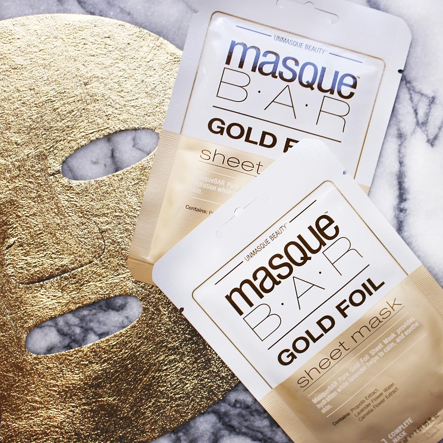 Two Masque Bar Gold Foil Sheet Masks displayed with a gold foil mask on marble background, ideal for radiant and balanced skin care.