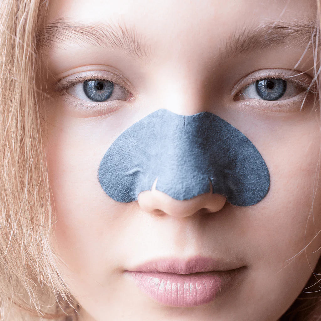 Close-up of a person wearing Masque Bar Luminizing Charcoal Nose Strip for blackhead removal and pore purification on the nose area.