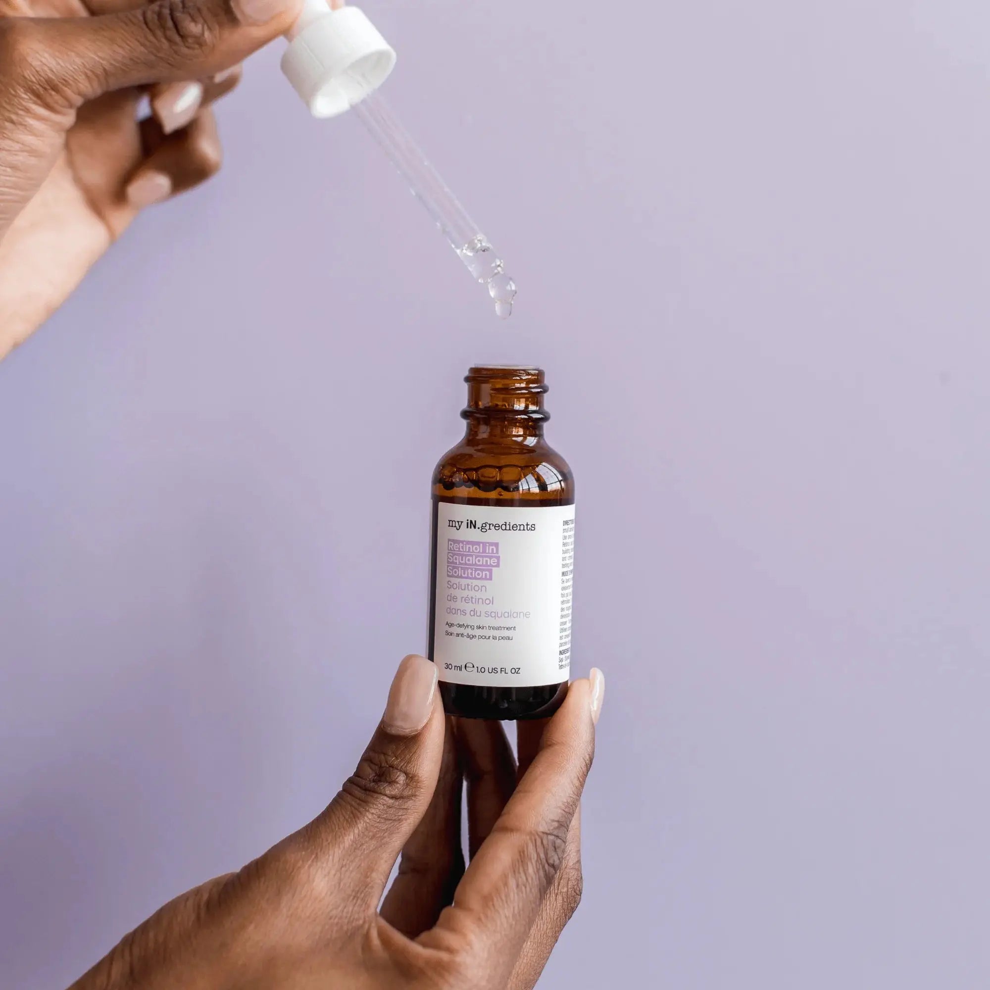 Hand holding My iN.gredients Retinol in Squalane Solution 30ml with dropper, perfect for refining skin texture and reducing fine lines.