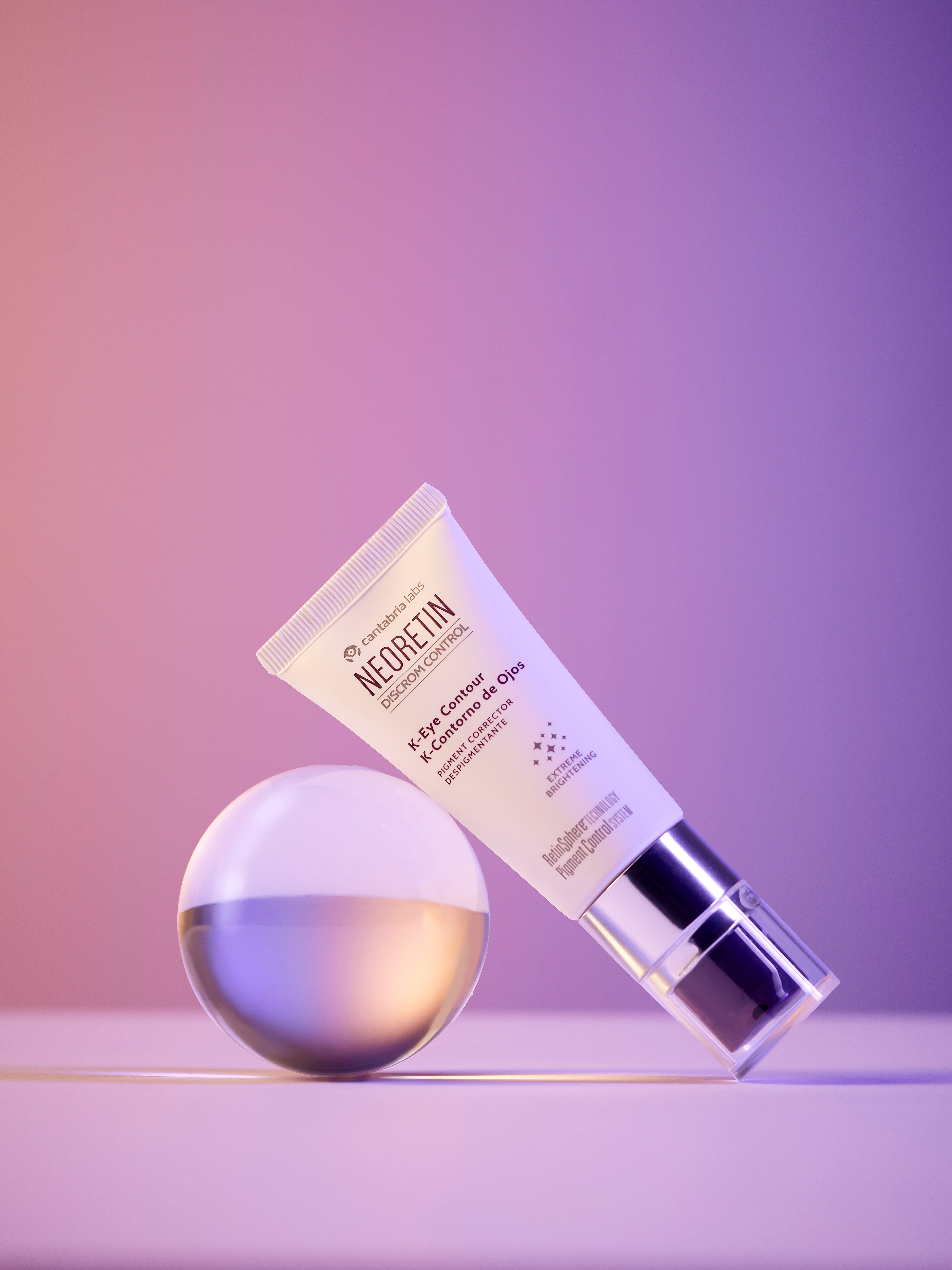 NEORETIN Discrom Control K-Eye Contour tube displayed with a glowing orb, emphasizing its brightening and pigment-correcting skincare benefits.