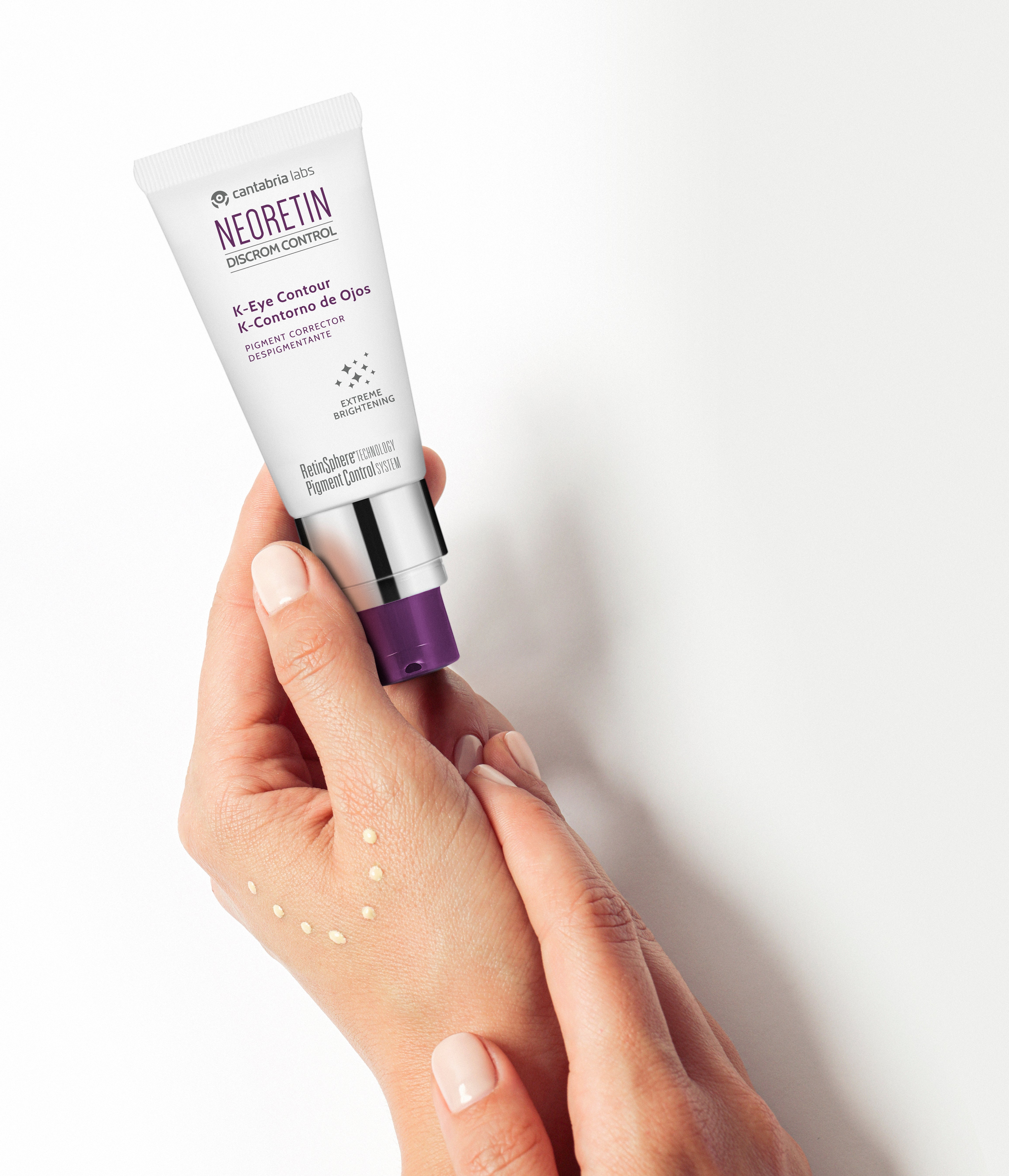 Hands applying NEORETIN Discrom Control eye cream, showcasing creamy texture for dark circle correction and wrinkle reduction on all skin types.