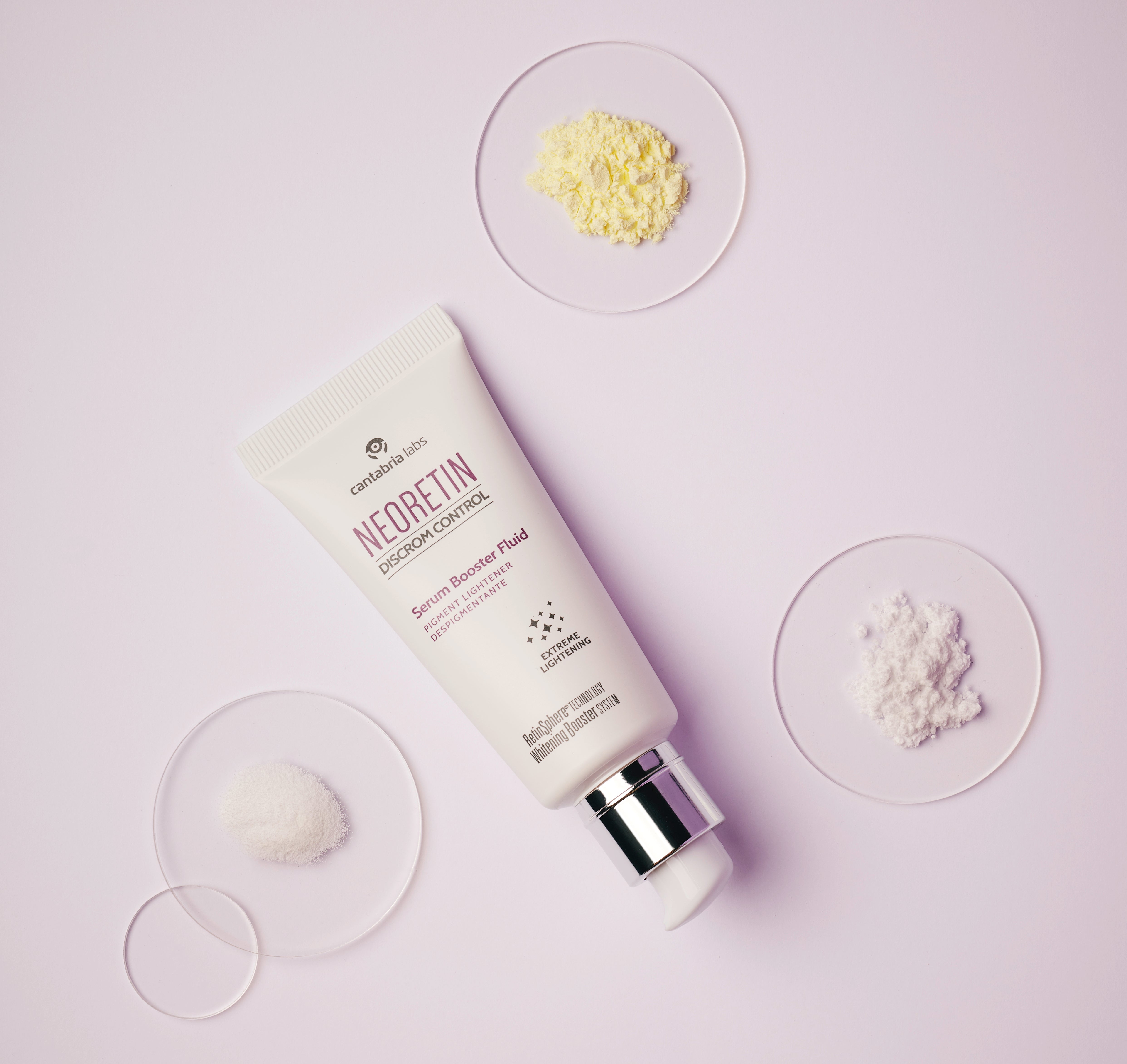 Neoretin Discrom Control Serum Booster Fluid 30ml flat lay with skincare ingredients, showcasing its brightening and anti-dark spot properties.