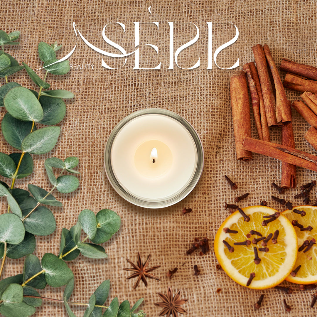 SerrBeauty Organic Beeswax Scented Candle surrounded by eucalyptus leaves, cinnamon sticks, cloves, and lemon slices, highlighting its refreshing and warm aroma.