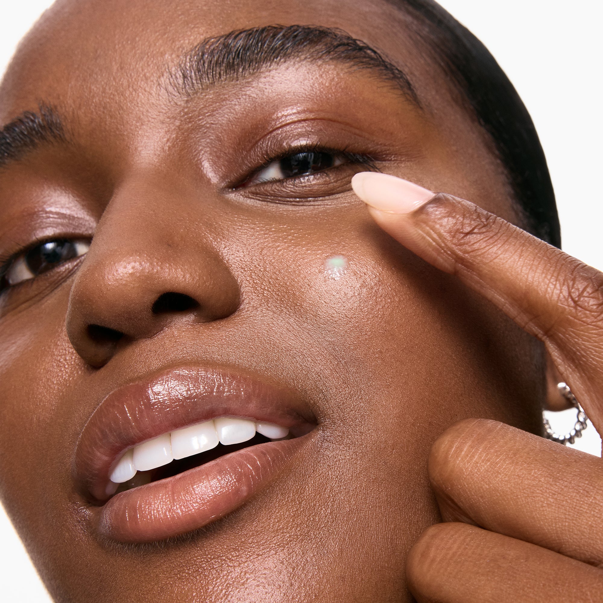 Close-up of woman applying Inkey List Succinic Acid Treatment to a blemish, highlighting gentle application for acne-prone skin.