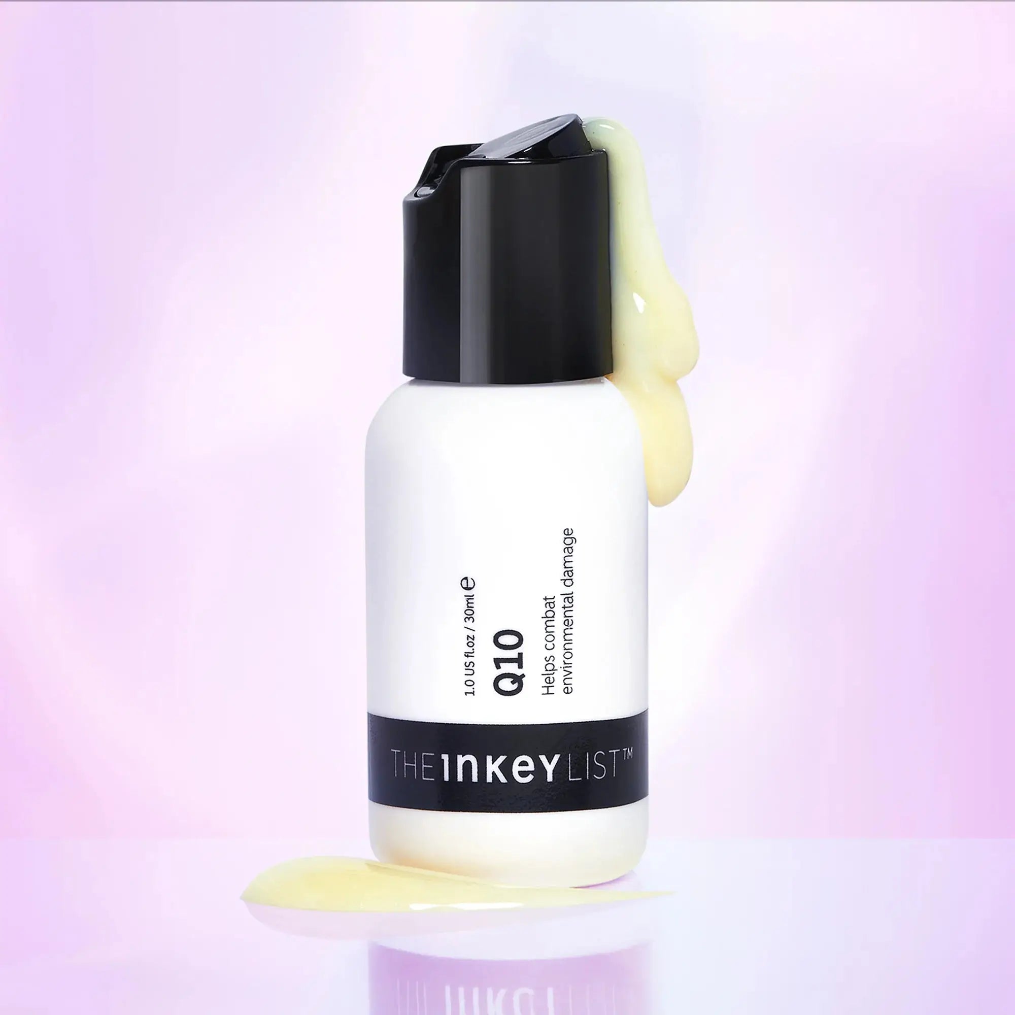 The Inkey List Q10 Serum 30 ml bottle with serum dripping down, set against a soft purple background, emphasizing its hydrating and anti-aging benefits.