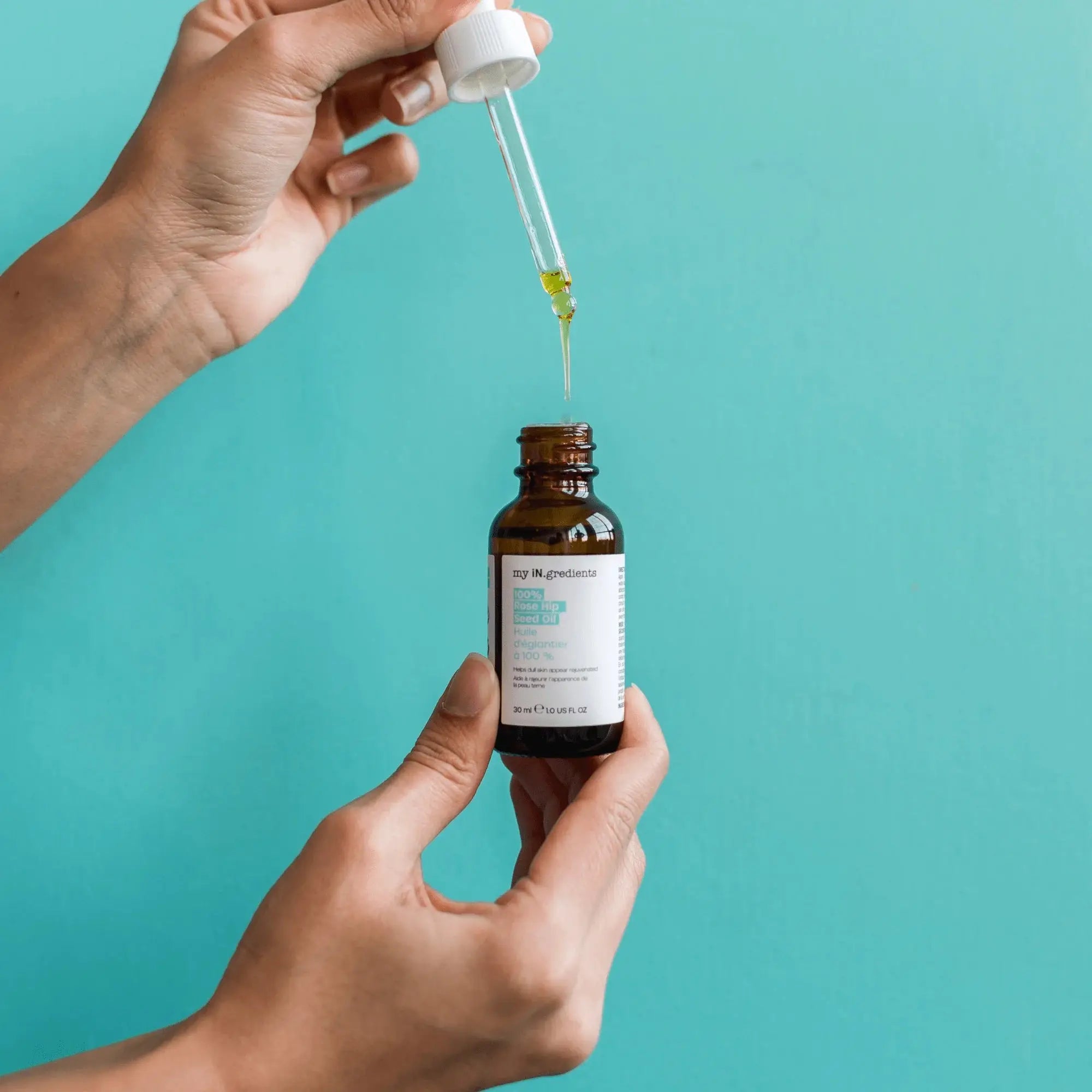 Hands using dropper to apply My iN.gredients 100% Rosehip Seed Oil serum, suitable for hyperpigmentation and uneven skin tone.
