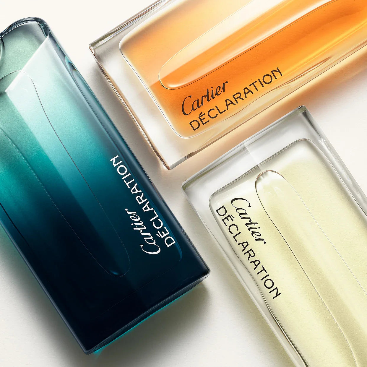 Elegant Cartier Déclaration perfume bottles in vibrant gradient hues.