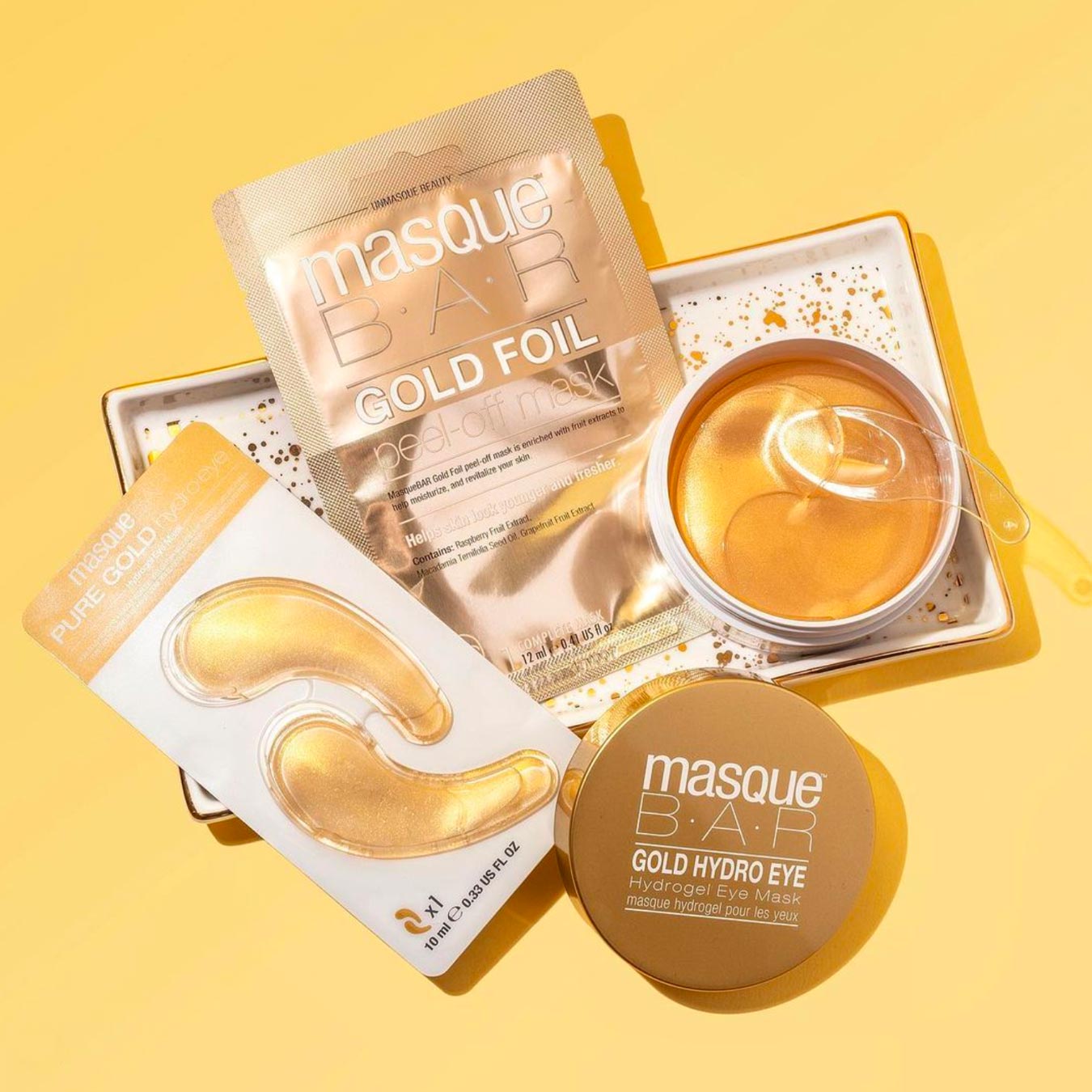 Luxurious Masque Bar gold foil and hydro eye masks on golden tray.
