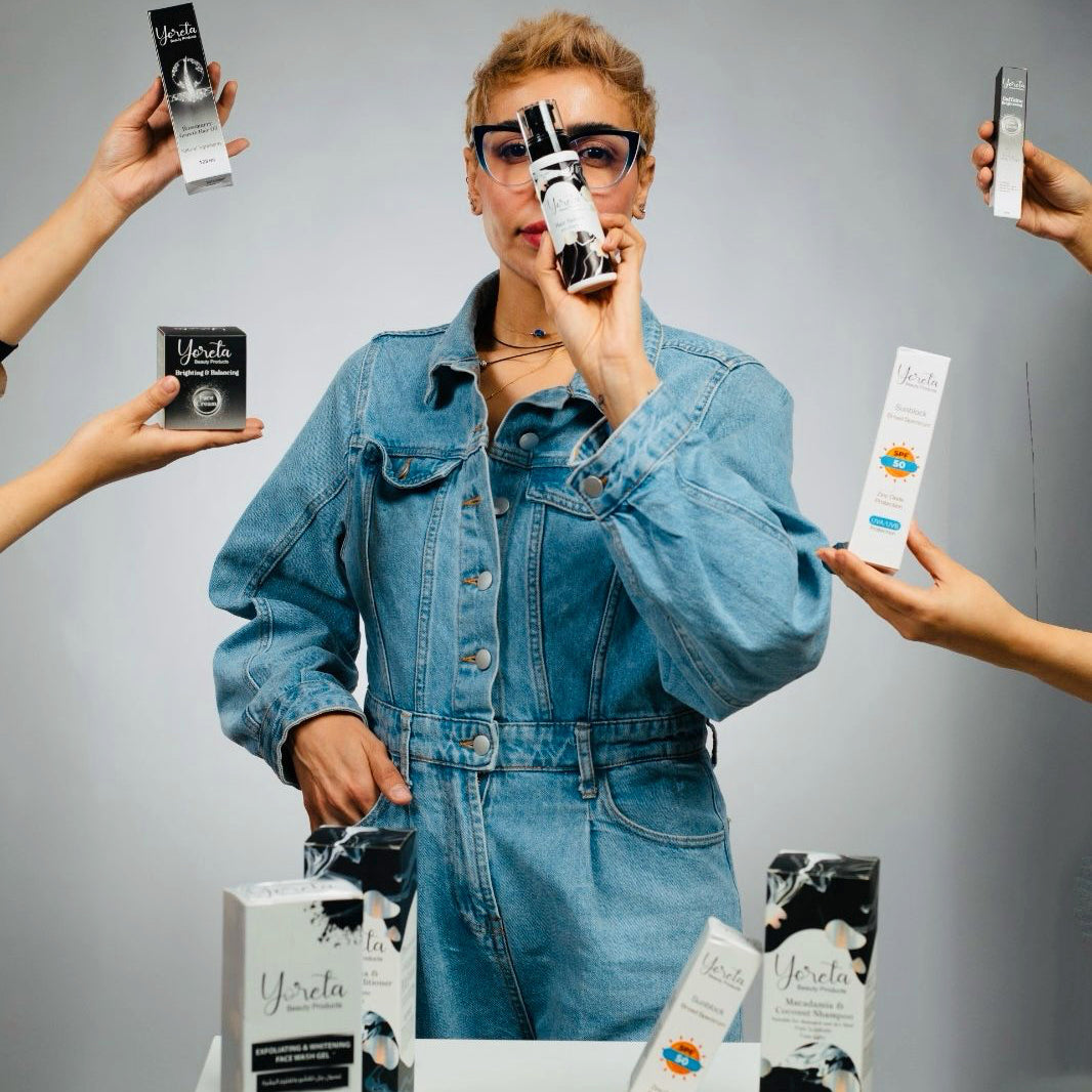 Woman in denim surrounded by Yoreta skincare products.