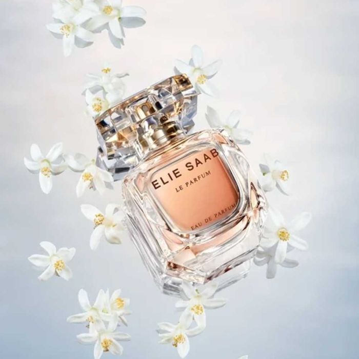 Elie Saab Le Parfum EDP 90ml surrounded by jasmine flowers, emphasizing floral notes of jasmine, orange blossom, and cedarwood.