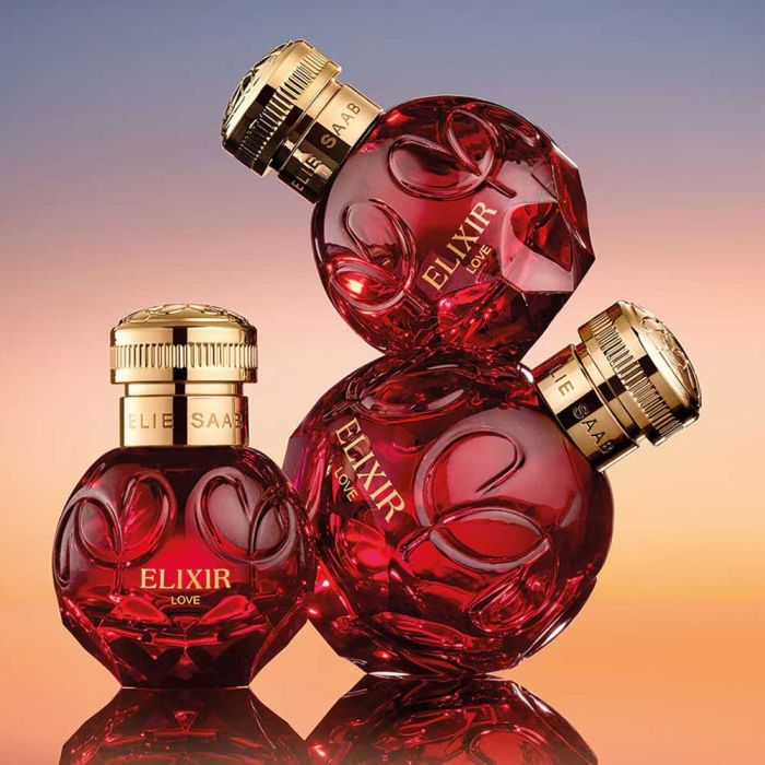 Three Elie Saab Elixir Love Perfume bottles stacked artistically, showcasing the luxurious design and floral cherry scent appeal.