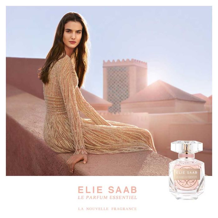 Elegant woman in gold dress with Elie Saab Le Parfum Essentiel 90ml EDP, showcasing the perfume's luxurious and feminine essence.