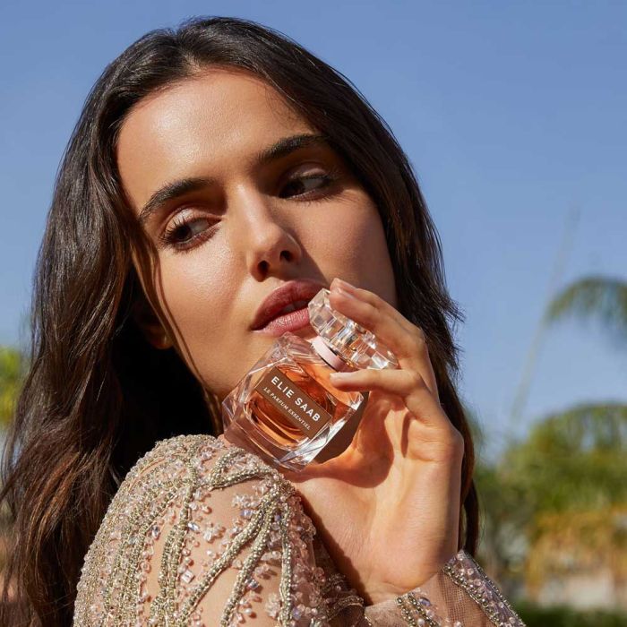 Close-up of woman holding Elie Saab Le Parfum Essentiel 90ml EDP, highlighting the perfume’s sophistication and allure for women.