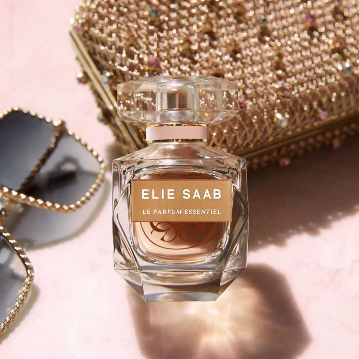 Elie Saab Le Parfum Essentiel 90ml EDP placed beside chic accessories, emphasizing its role as a stylish and essential fragrance for women.