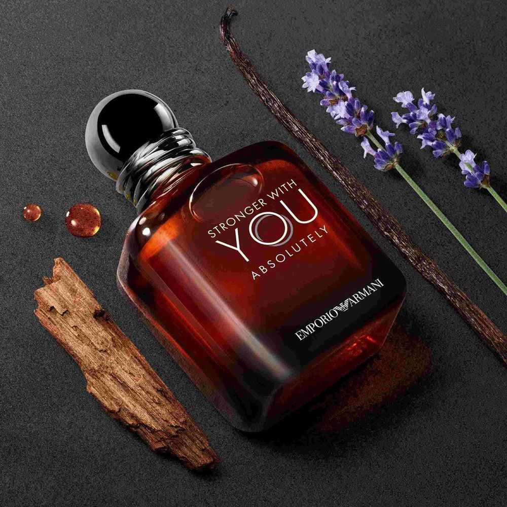 Emporio Armani Stronger With You Absolutely Parfum bottle styled with vanilla, lavender, and rum ingredients on a dark background.