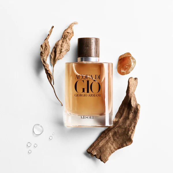 Giorgio Armani Acqua Di Gio Absolu EDP 100 ml bottle styled with amber, wood, and dried leaves, highlighting its earthy, aquatic scent.