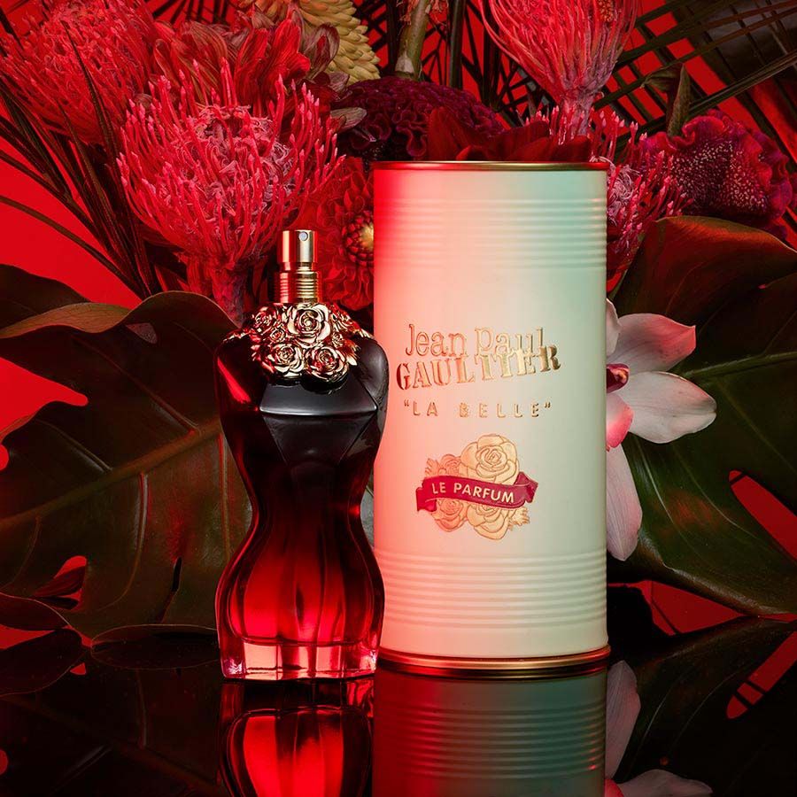 Jean Paul Gaultier La Belle EDP displayed with floral decor and packaging, highlighting its pear, tonka, and vanilla scent profile.