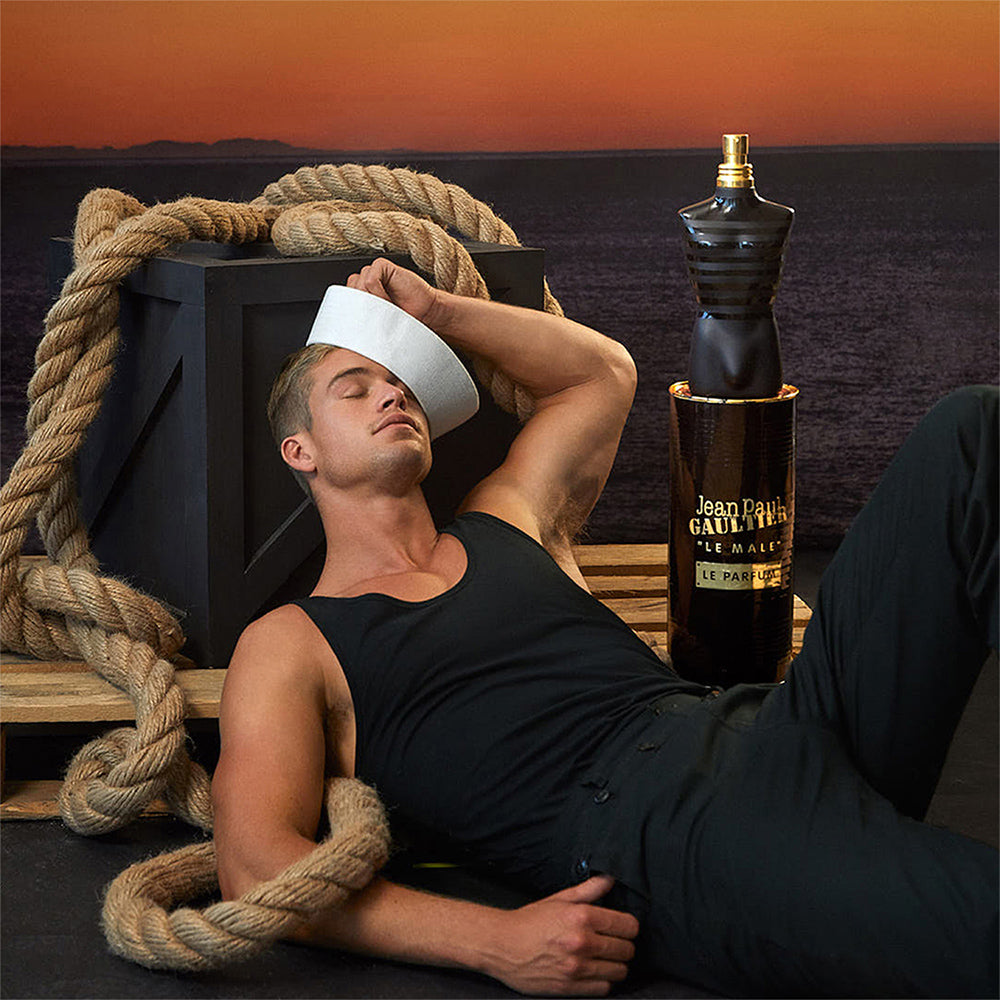 Jean Paul Gaultier Le Male Intense Perfume featured with a sailor-themed model and oversized bottle, evoking masculine and adventurous vibes.