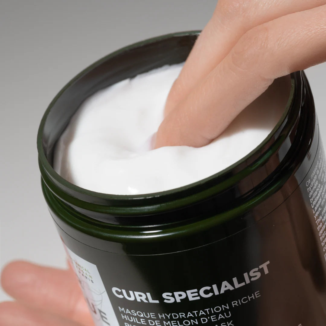 Close-up of Lazartigue Curl Mask creamy texture being scooped, showing rich hydration for curly hair. Ideal for frizz control and curl definition.