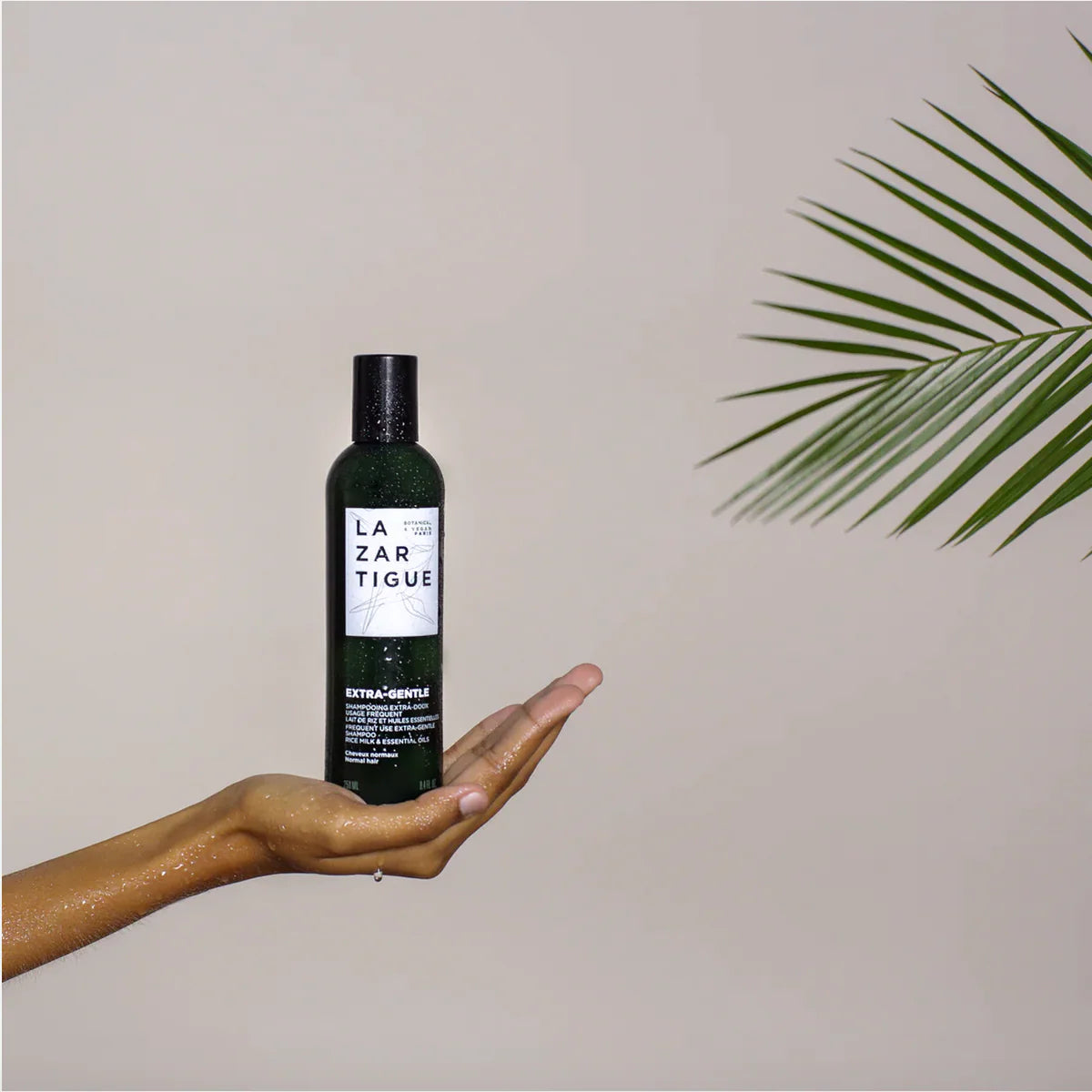 Hand holding Lazartigue Extra-Gentle Shampoo 250 ml bottle with minimalist background, highlighting its vegan, sulfate-free, and natural formula.