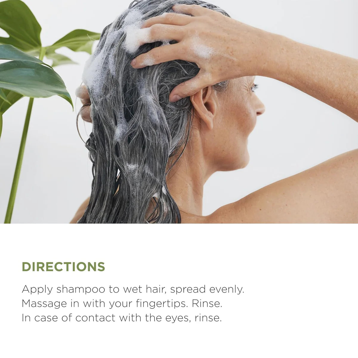 Woman massaging Lazartigue Fortify Shampoo into wet hair, demonstrating application for strengthening thinning hair.