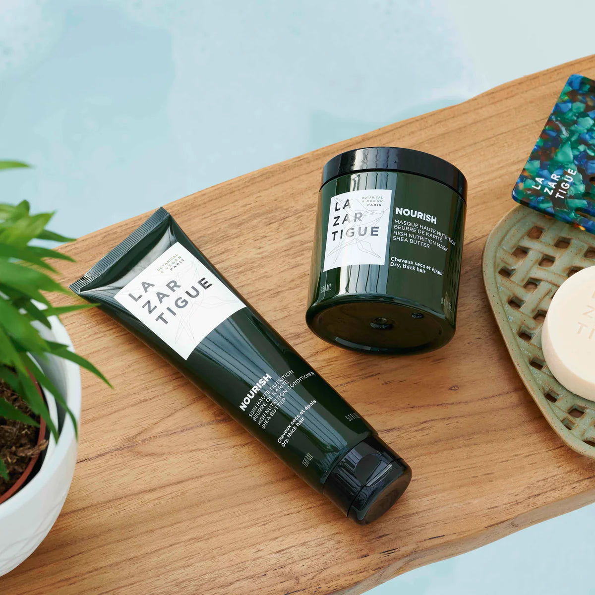 Lazartigue Nourish Conditioner and hair mask on wooden surface, part of a vegan hair care routine for deep hydration and shine.