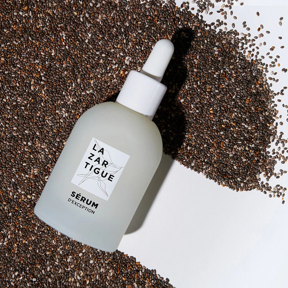 Lazartigue d'Exception Hair Serum bottle placed on chia seeds, highlighting its natural, essential oil-infused, vegan ingredients.