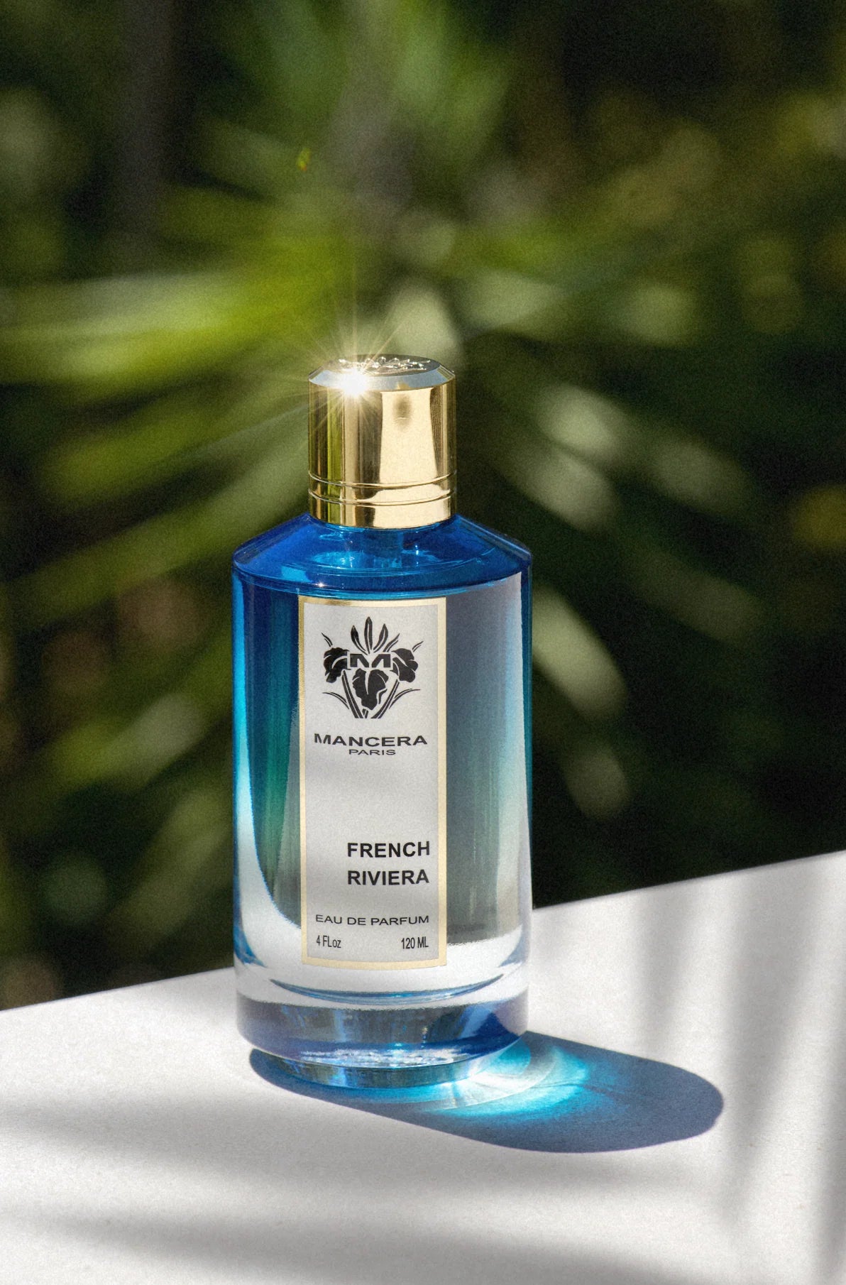 Mancera French Riviera Perfume - 120 ml bottle displayed in sunlight, highlighting its elegant blue gradient design for men and women.