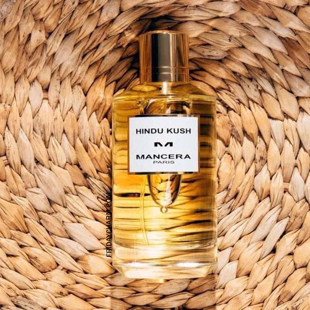 Mancera Hindu Kush Eau De Parfum 120ml bottle on woven mat, showcasing its golden hue and premium woody oriental fragrance appeal.