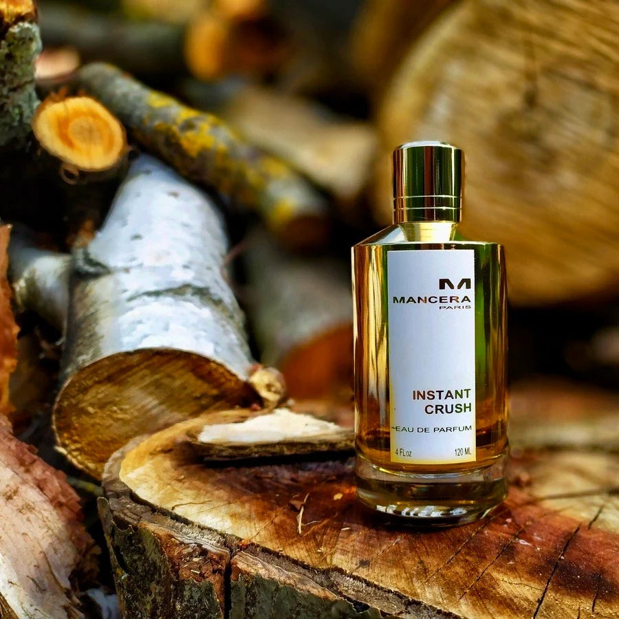Instant Crush by Mancera Eau De Parfum 120 ml placed on chopped wood, reflecting its warm amber and woody fragrance profile.