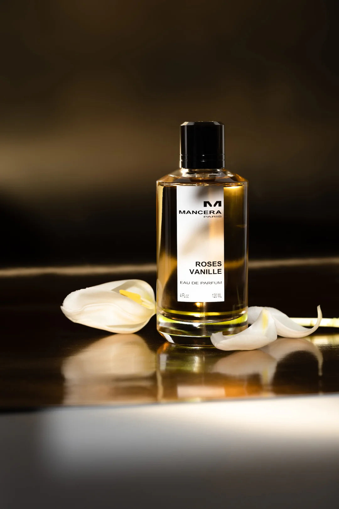 Mancera Roses Vanille Perfume 120 ml showcased on a reflective surface with white petals, emphasizing its elegant and musky aroma.