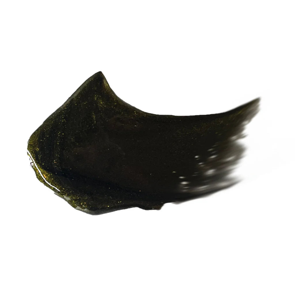 Swatch of Masque Bar Black Gold 24K Peel-Off Mask showing its rich black and gold shimmer texture for radiant skin detox and exfoliation.
