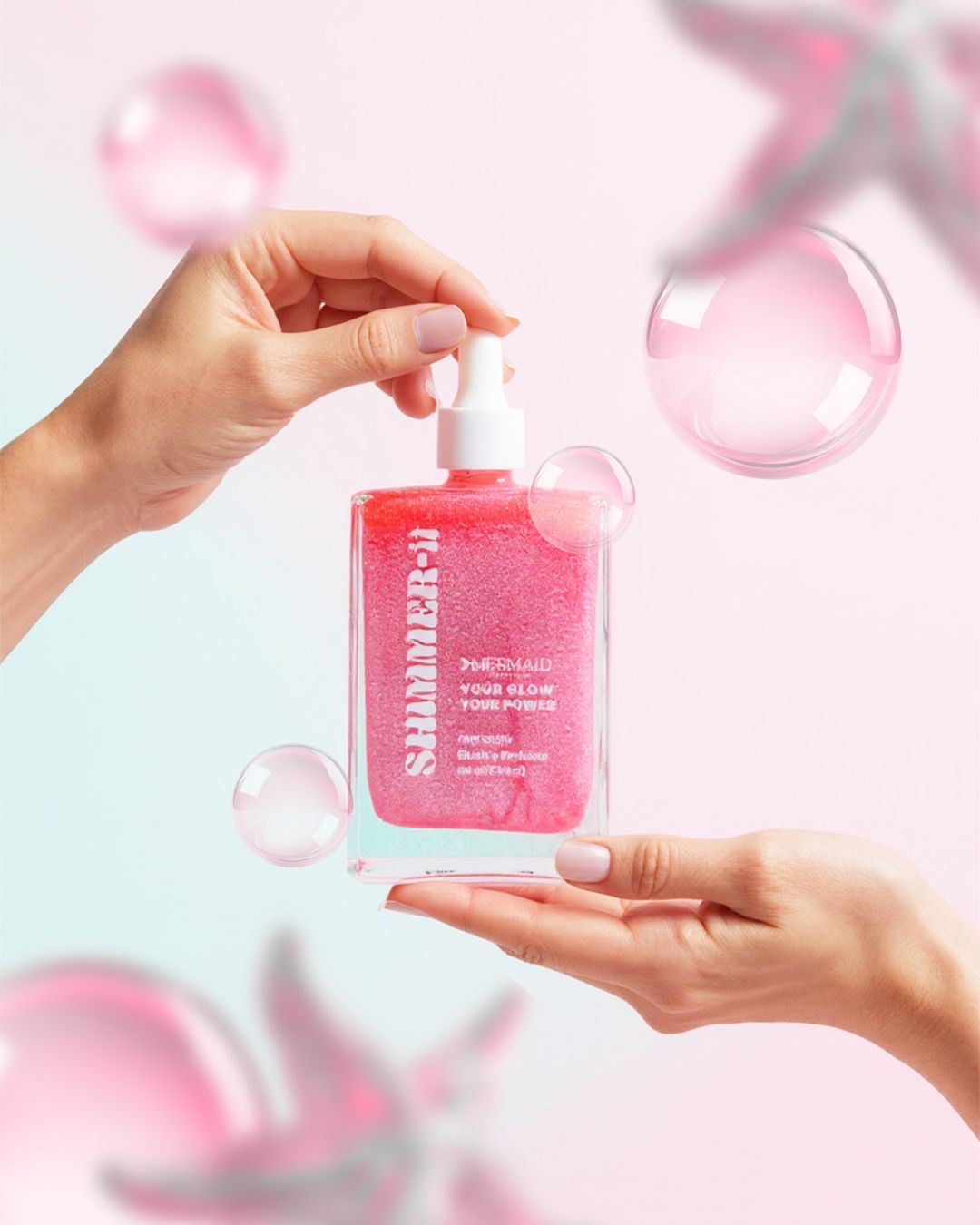 Mermaid Pink Oil - Shimmering Body Oil in a dropper bottle held between hands. Infused with Blushe Perfume for glowing, soft, and nourished skin.