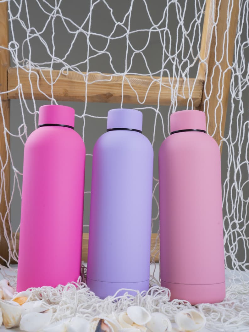 Colorful 500ml Mermaid vacuum insulated bottles in a beach-themed setup, eco-friendly and stylish for home or outdoor use.