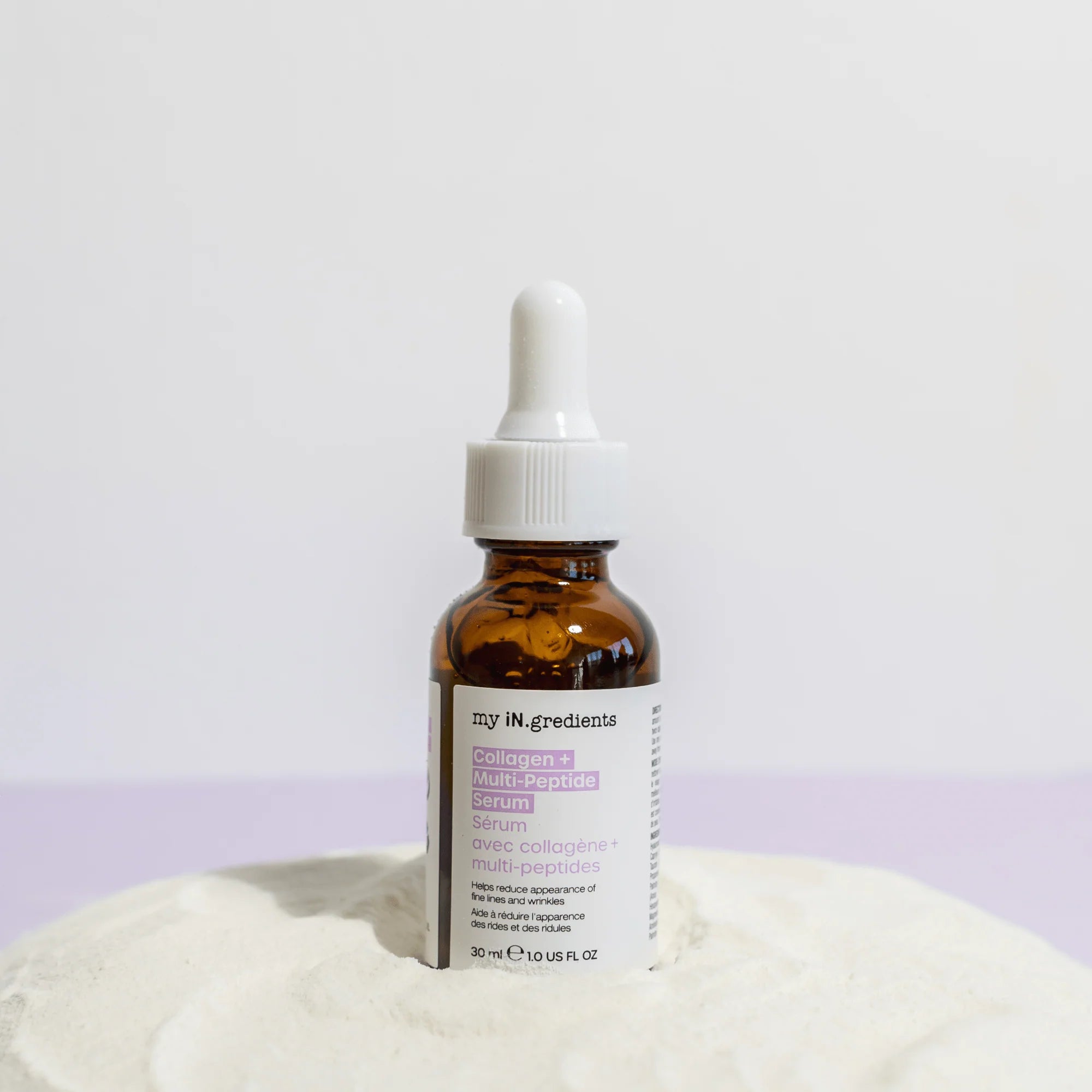 My iN.gredients Collagen + Multi-Peptide Serum 30 ml bottle placed on white textured surface, ideal for sensitive and blemish-prone skin.