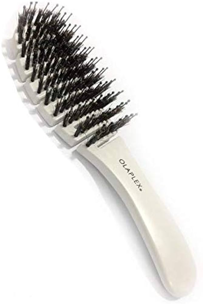 Olaplex Detangling Professional Hair Brush featuring a contoured shape and densely packed bristles for smooth, shiny, frizz-free styling.