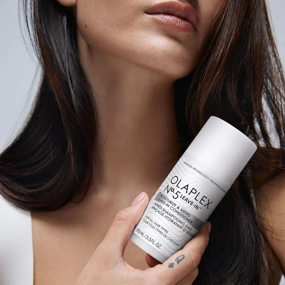 Model holding Olaplex No.5 Leave-In Conditioner 100ml, showcasing its premium hair care benefits for dry, brittle, and chemically treated hair.