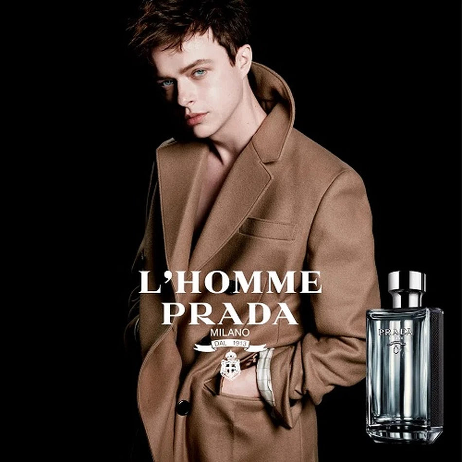 Model in brown coat promoting Prada L'Homme Eau - Men's Fragrance, showcasing the elegant woody chypre scent for men.