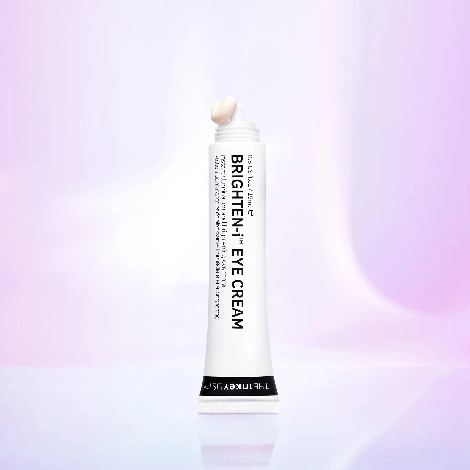 The Inkey List Brightening Eye Cream 15 ml tube standing against a soft purple gradient background, emphasizing its illuminating and hydrating properties.