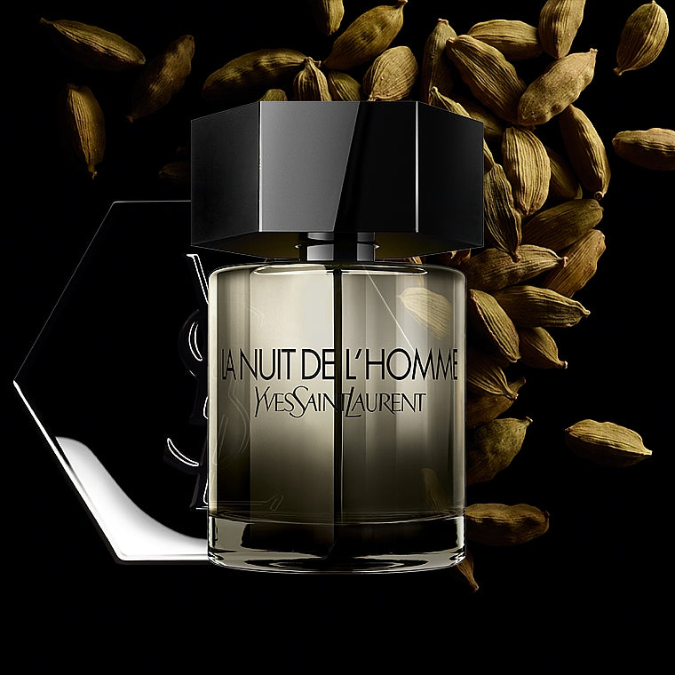YSL La Nuit de L'Homme perfume bottle with cardamom pods in background, highlighting its woody spicy scent for men.