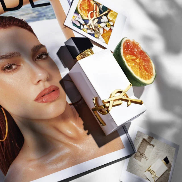 YSL Libre L'Eau Nue Perfume showcased with citrus fruits and fashion magazine, highlighting its fresh, vibrant citrus scent for women.