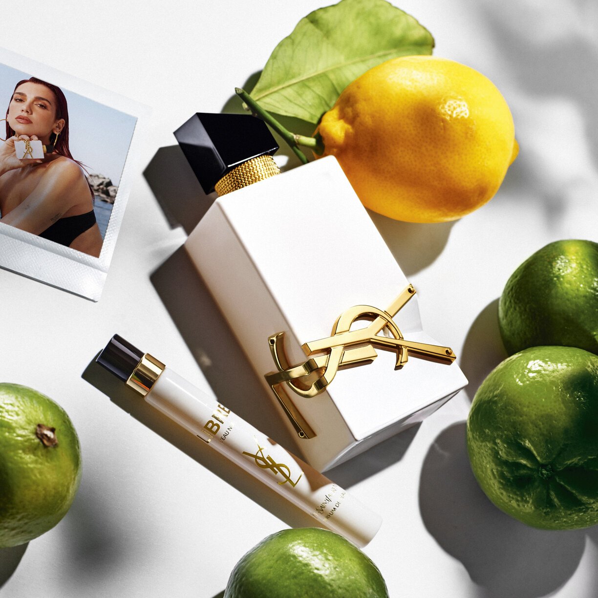 YSL Libre L'Eau Nue Perfume bottle with citrus fruits and travel-size spray, showcasing its zesty fragrance and elegant packaging.